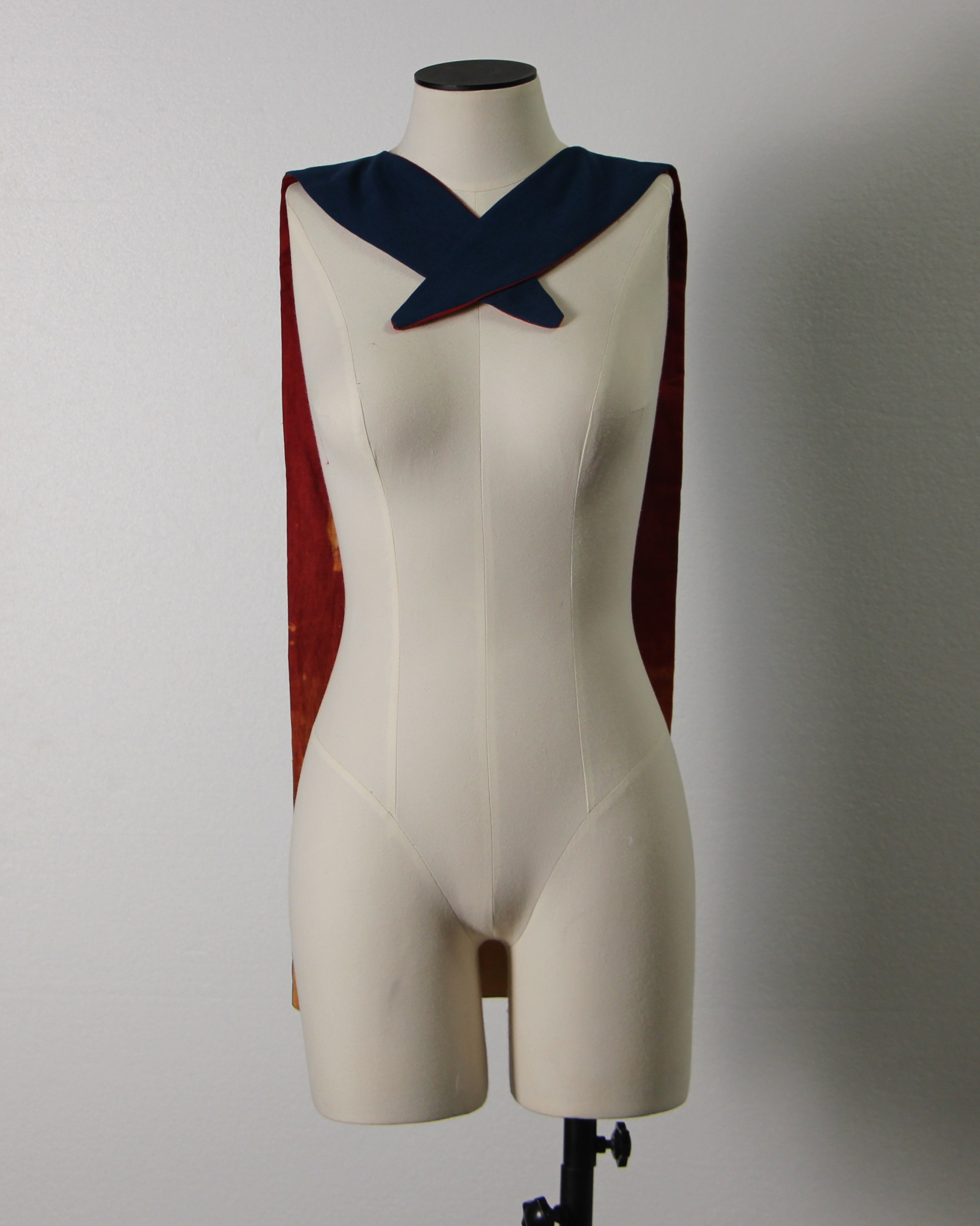 Blue linen cape with bleached red linen lining draped on a mannequin, front