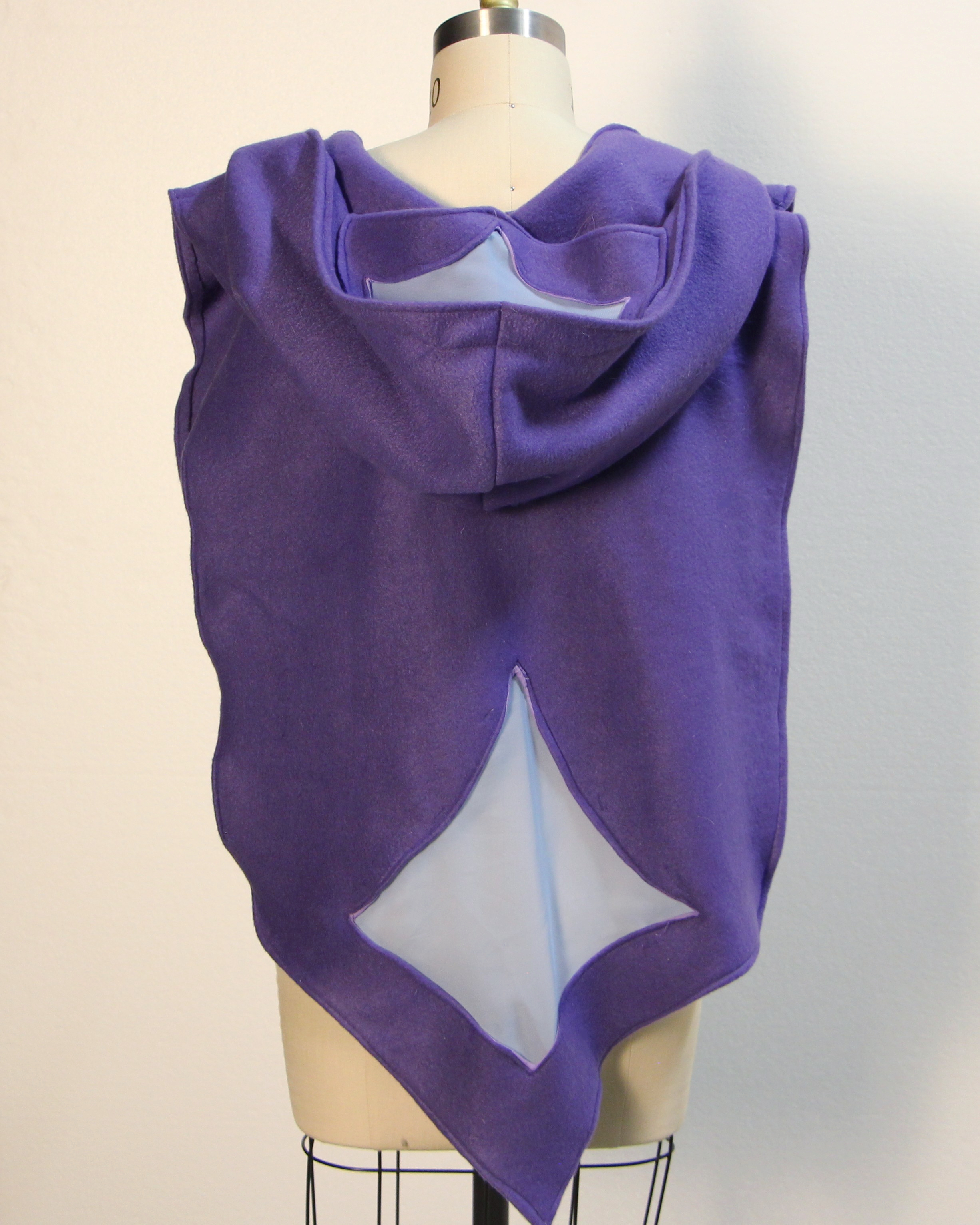 Purple fleece cape with hood and light blue cutouts on mannequin, back